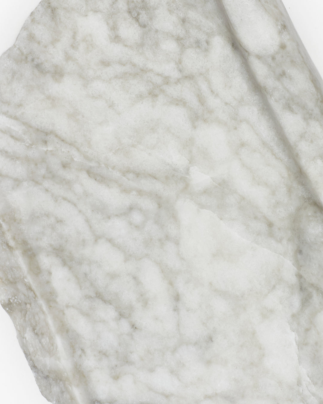 Top-down close-up: light gray-green alabaster surface, gray streaks, and light veining.