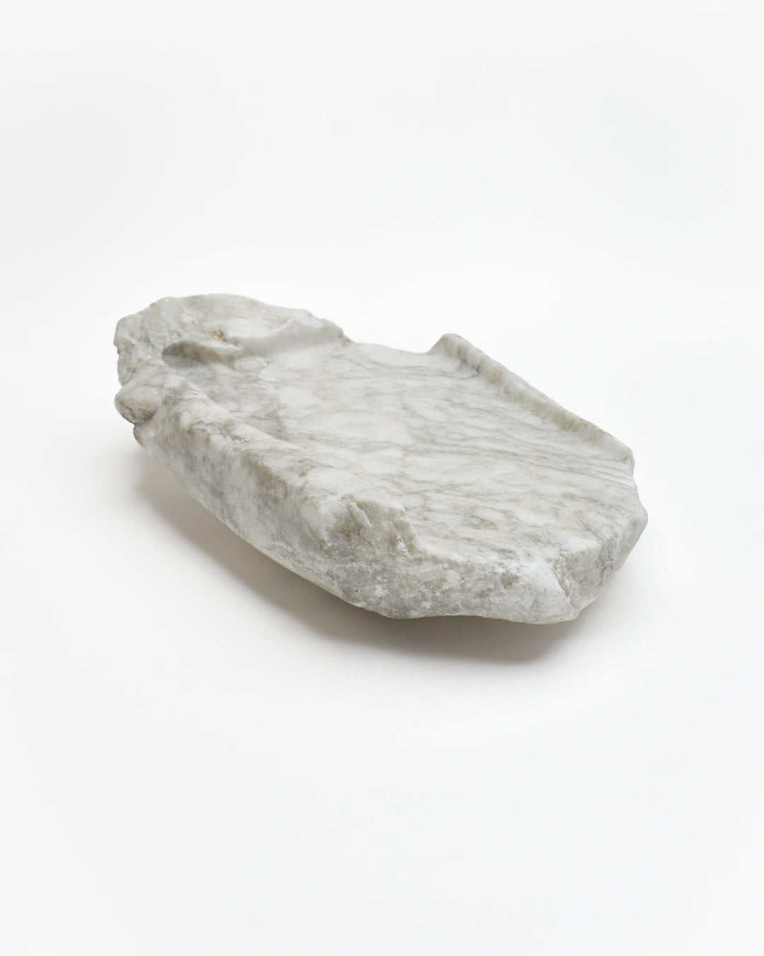 Angled view: gray-green alabaster tray with gray streaks, beige flecks, smooth and raw edges.
