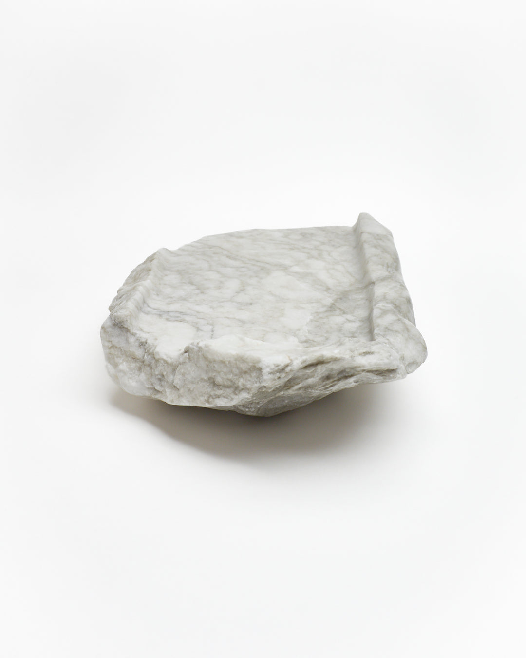 Back view: gray-green alabaster tray with gray streaks, smooth and raw edges.