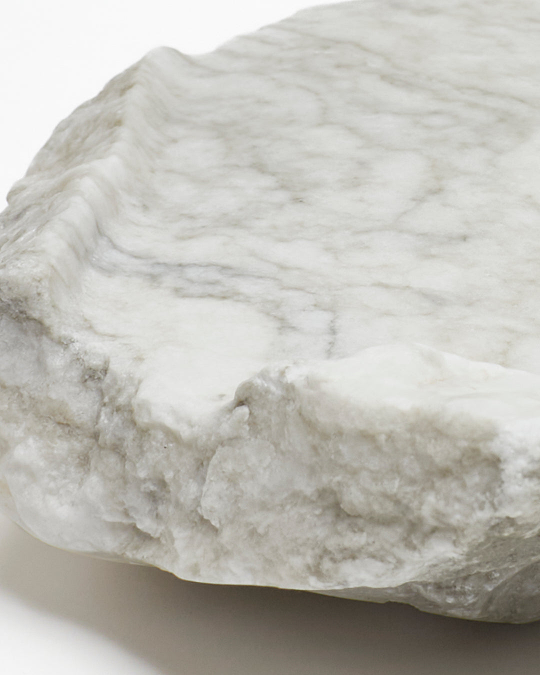 Close-up: light gray-green alabaster tray with gray streaks.