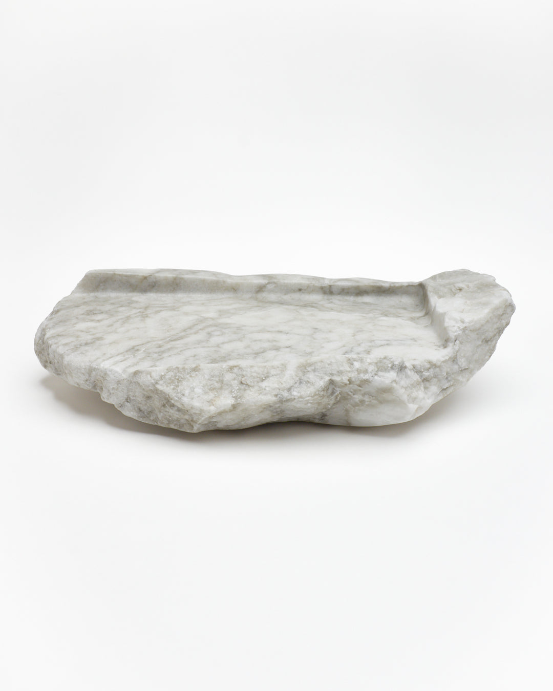 Side view: gray-green alabaster tray with gray streaks, beige flecks, smooth and raw edges.