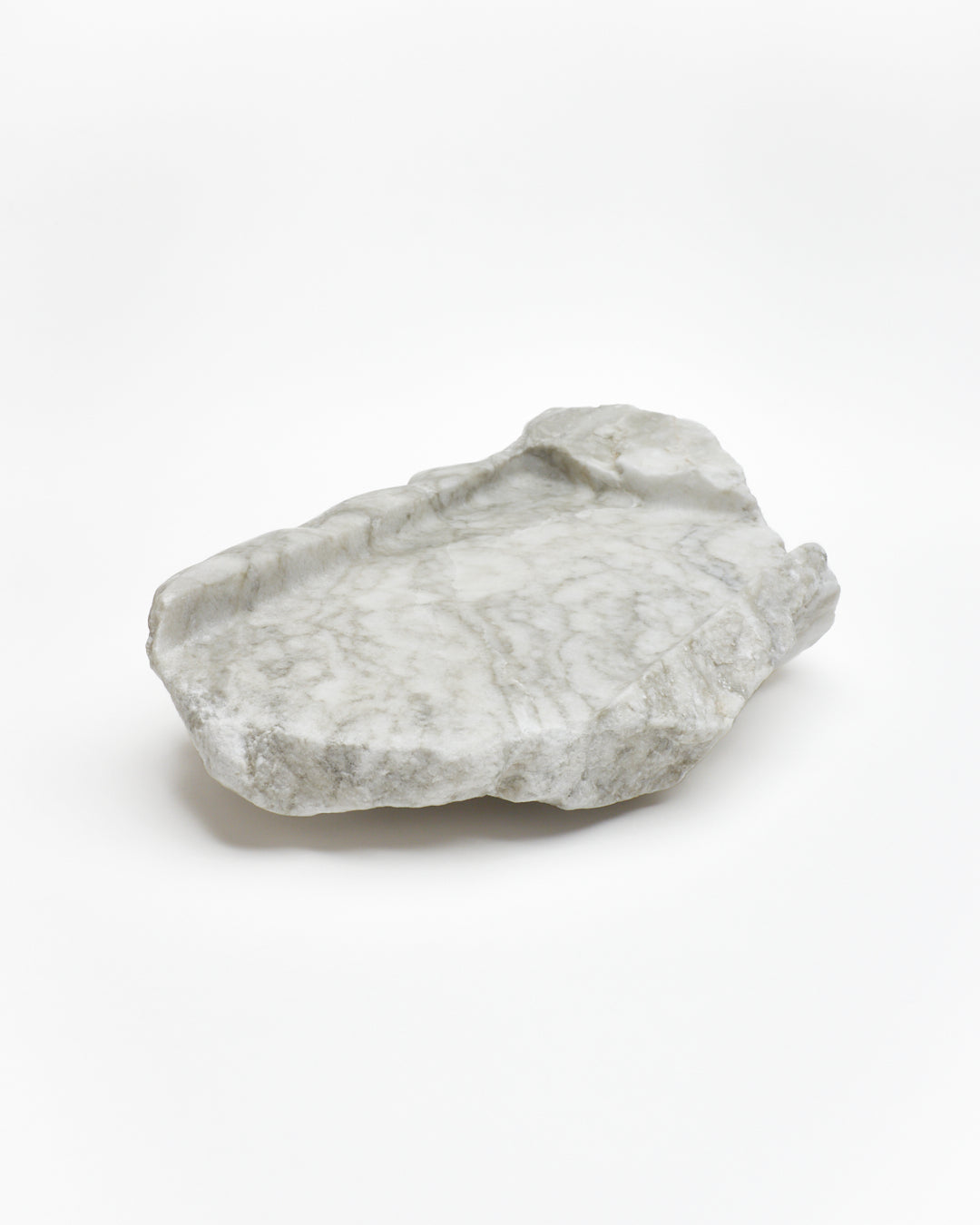 Angled view: gray-green alabaster tray with gray streaks, beige flecks, smooth and raw edges.