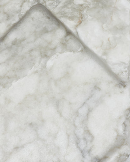 Top-down close-up: light gray-green alabaster surface, gray streaks, light veining, beige flecks.