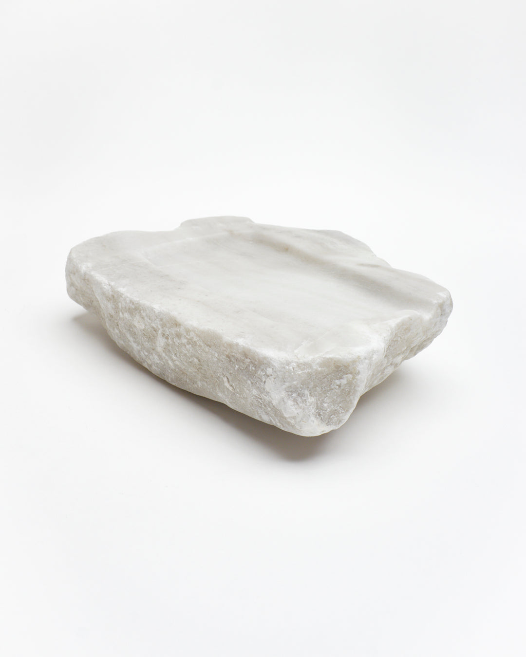 Angled view: organic-rectangle off-white alabaster tray with raw edges and subtle marks.