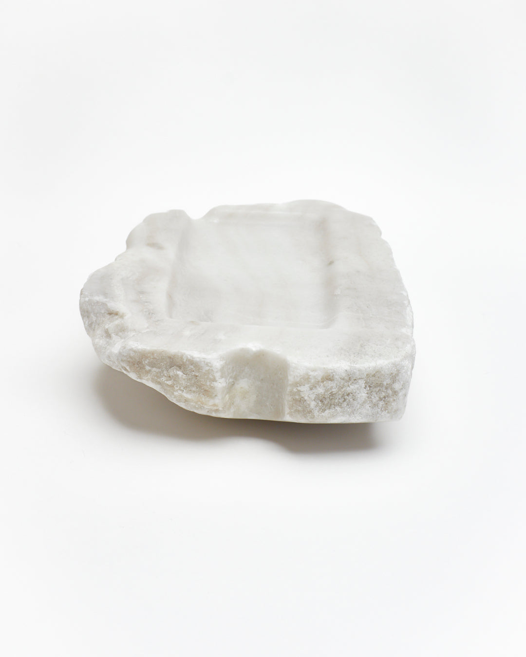 Back view: organic-rectangle off-white alabaster tray with raw edges, marks, semicircle cutout.