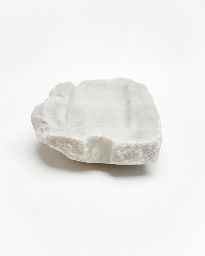 Back view: organic-rectangle off-white alabaster tray with raw edges, marks, semicircle cutout.