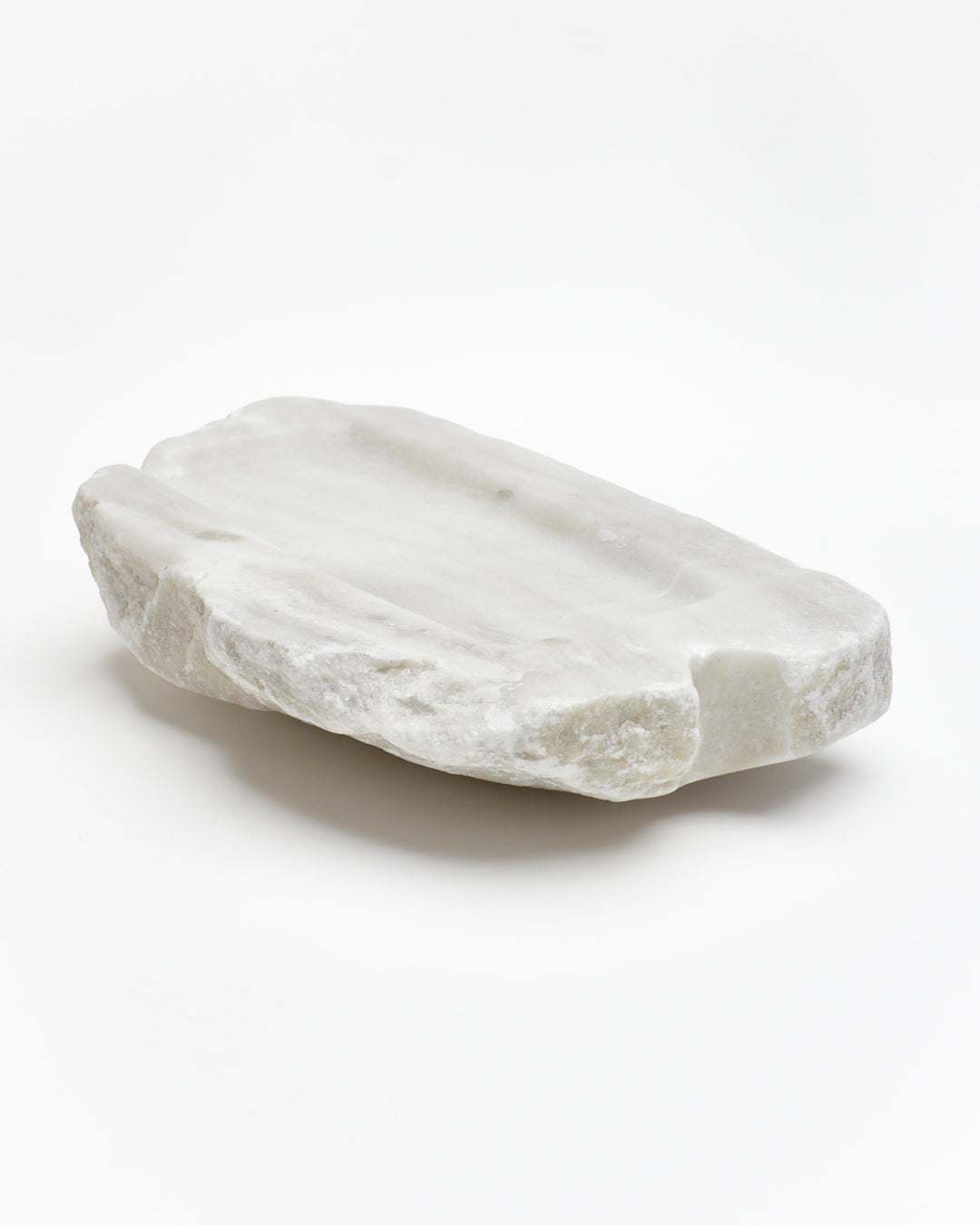 Angled back view: organic-rectangle off-white alabaster tray with raw edges subtle marks, cutout.