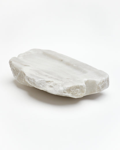 Angled back view: organic-rectangle off-white alabaster tray with raw edges subtle marks, cutout.