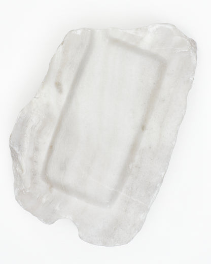 Top-down: organic-rectangle off-white alabaster tray, subtle marks, semicircle cutout.