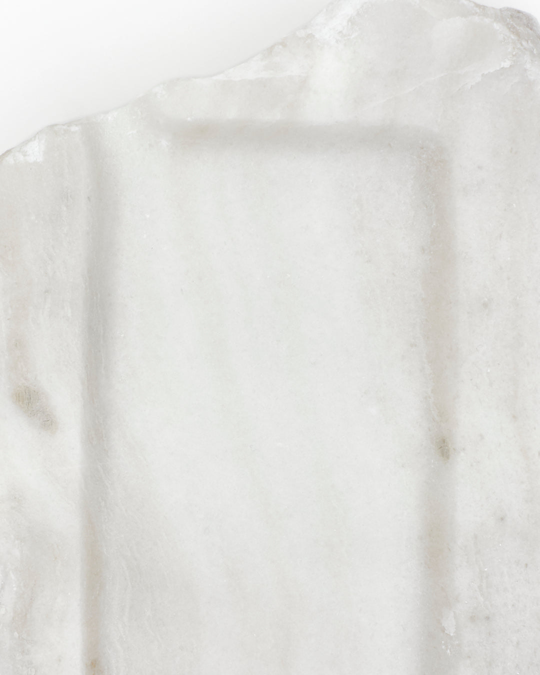 Top-down close-up: polished off-white alabaster surface with subtle marks. 