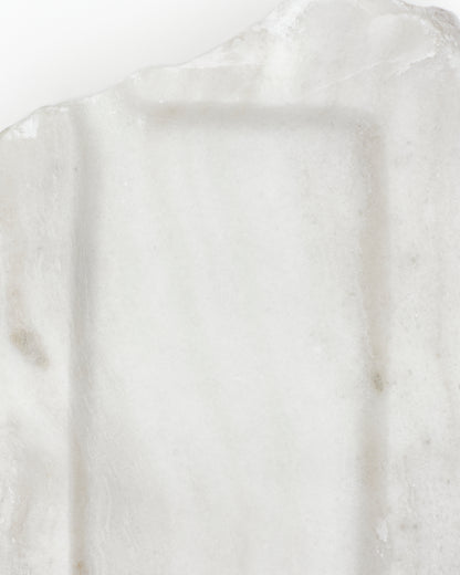Top-down close-up: polished off-white alabaster surface with subtle marks. 