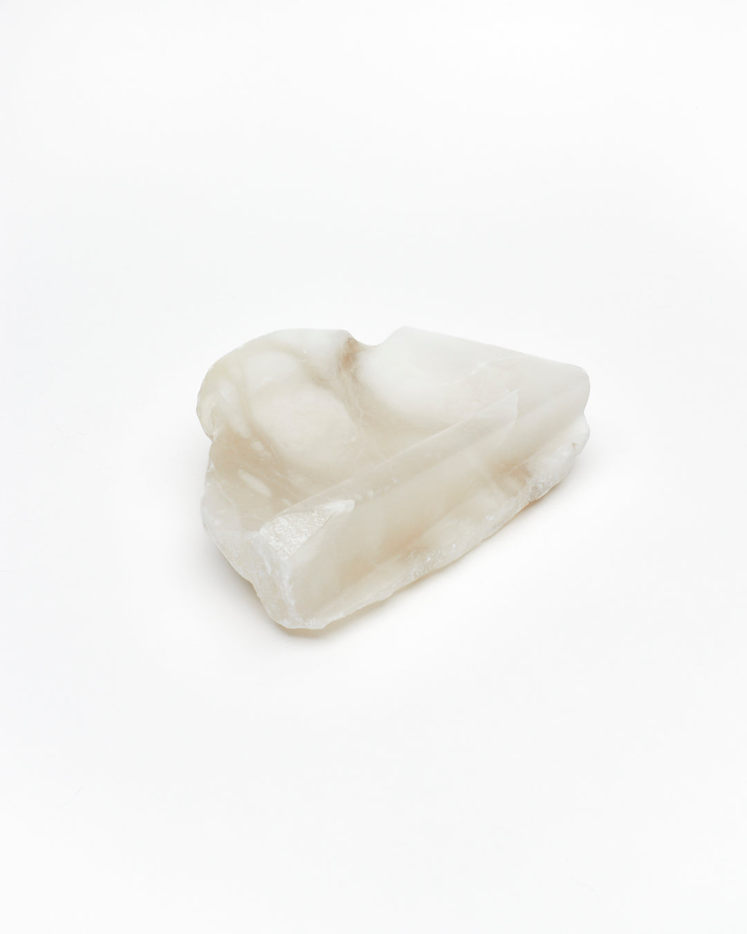 Angled view: white translucent alabaster tray with raw and smooth edges.