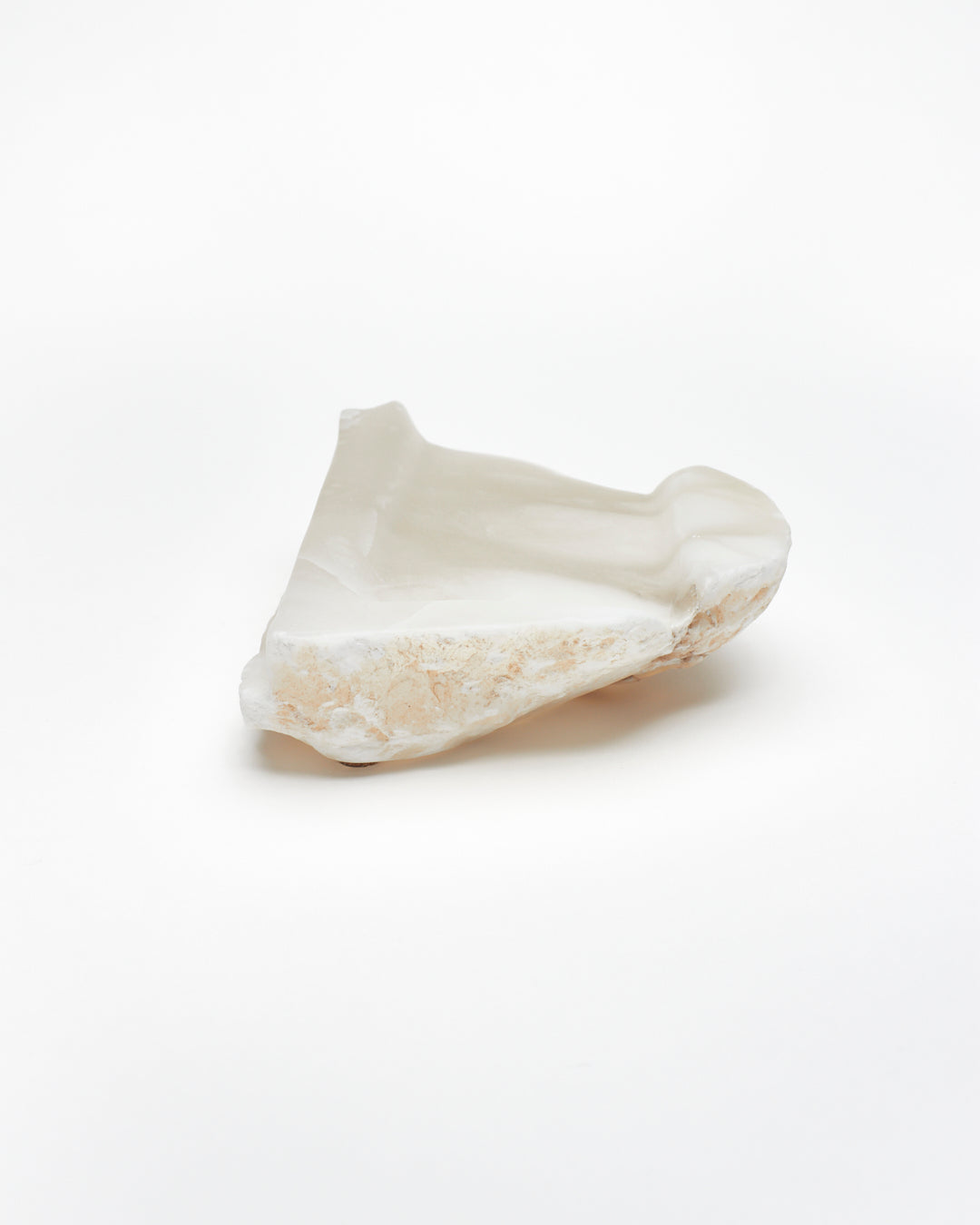 Back view: white translucent alabaster tray with brown flecks, and raw edges.