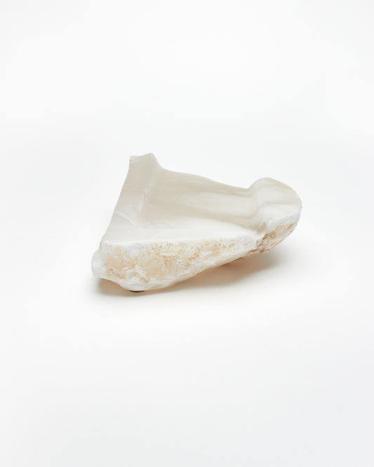 Back view: white translucent alabaster tray with brown flecks, and raw edges.