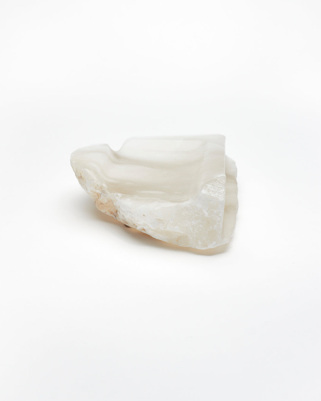 Front-on view: white translucent alabaster tray with brown flecks, raw and smooth edges.
