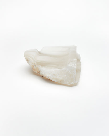 Front-on view: white translucent alabaster tray with brown flecks, raw and smooth edges.