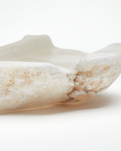 Close-up view: white translucent alabaster tray with brown flecks, raw and smooth edges.