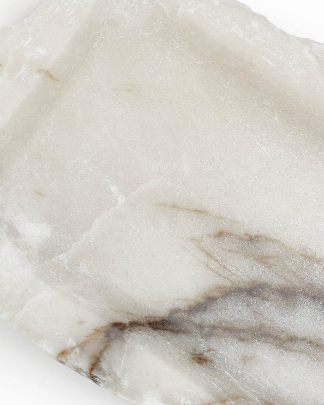 Top-down close-up: white alabaster surface with dark streaks