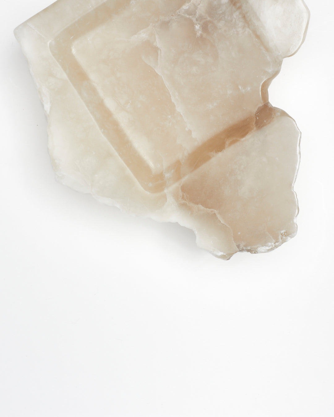Top-down view: organic-shaped tan and cream alabaster tray sculpture with veining.