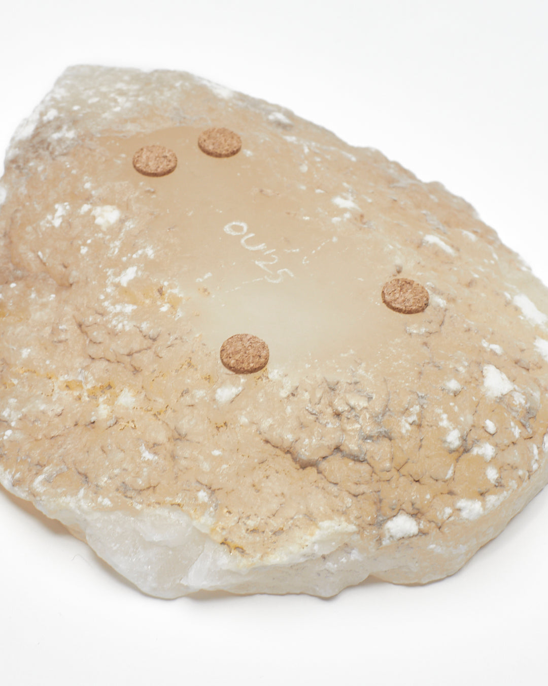 Underside: white translucent alabaster tray with raw surface, flecks, cork pads, OU'25 engraving.