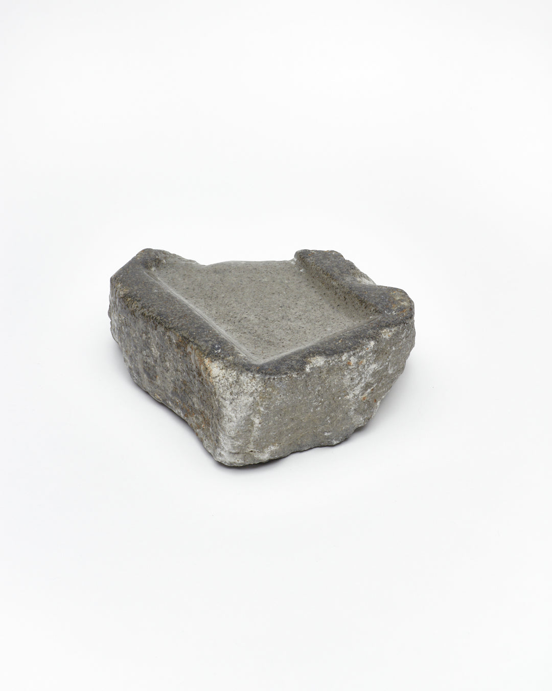 Angled back view: organic-rectangle-shaped gray stone tray with raw edges.