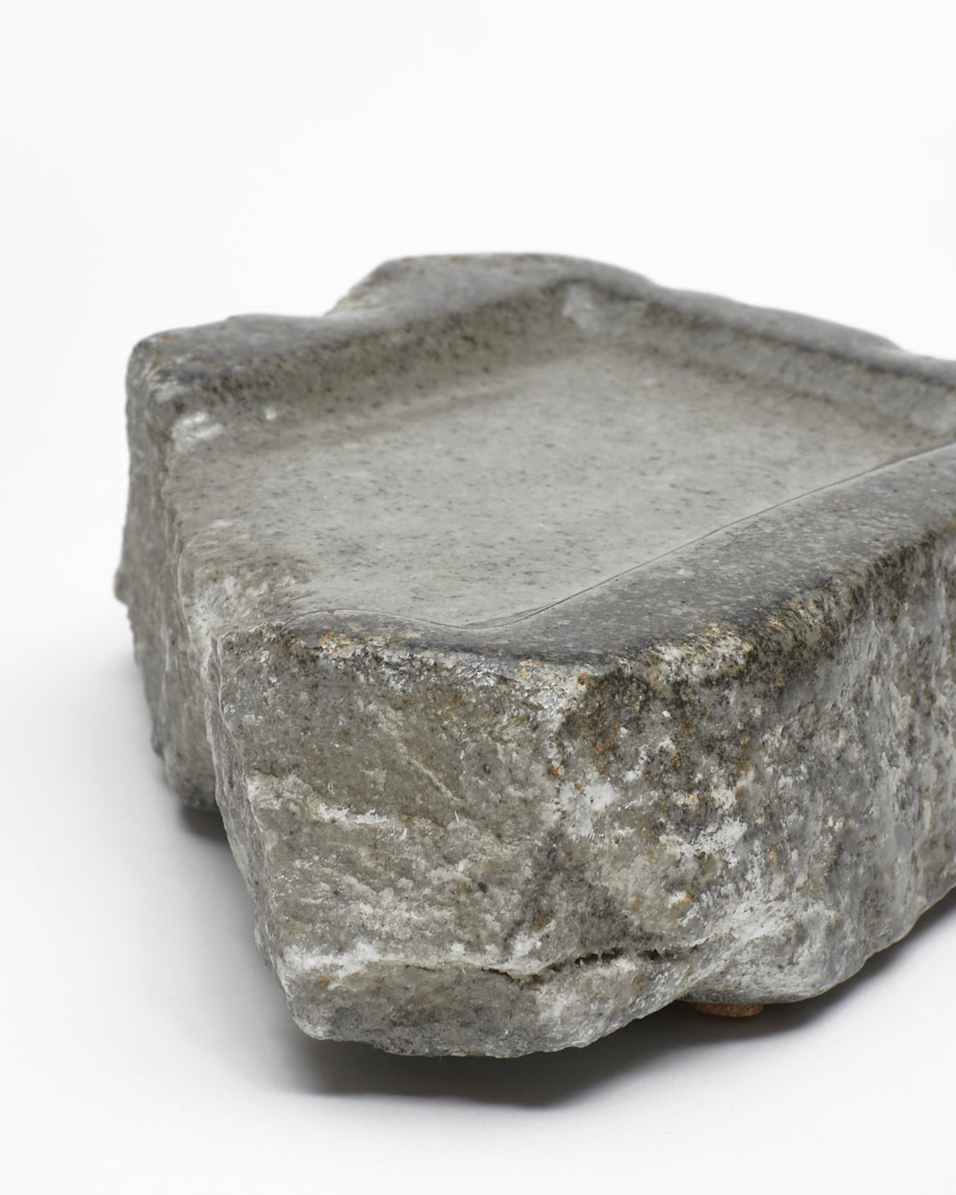 Angled close-up view: organic-rectangle-shaped gray stone tray with raw edges.