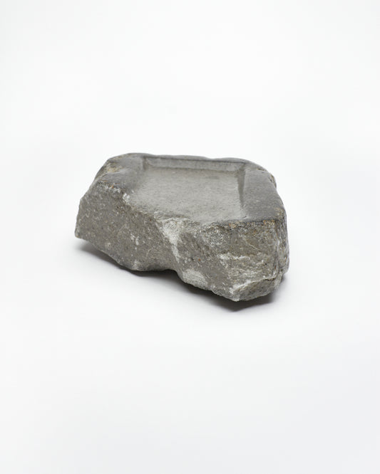 Front-on view: organic-rectangle-shaped gray stone tray with raw edges.