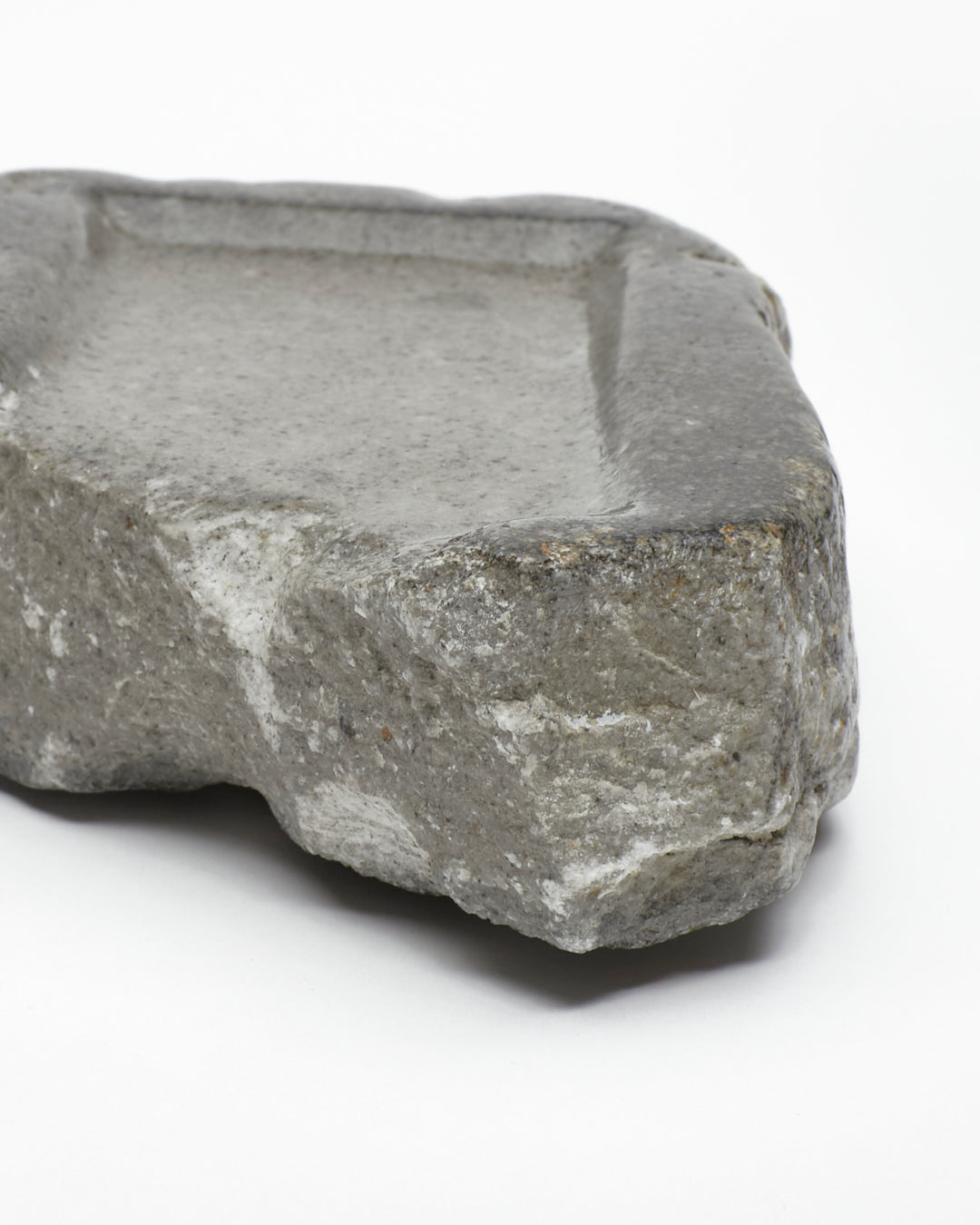 Front-on close-up: organic-rectangle-shaped gray stone tray with raw edges.