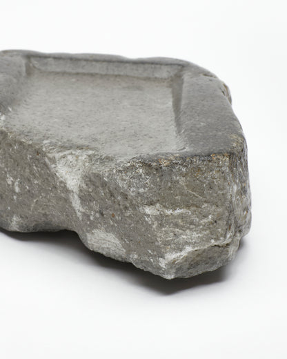 Front-on close-up: organic-rectangle-shaped gray stone tray with raw edges.