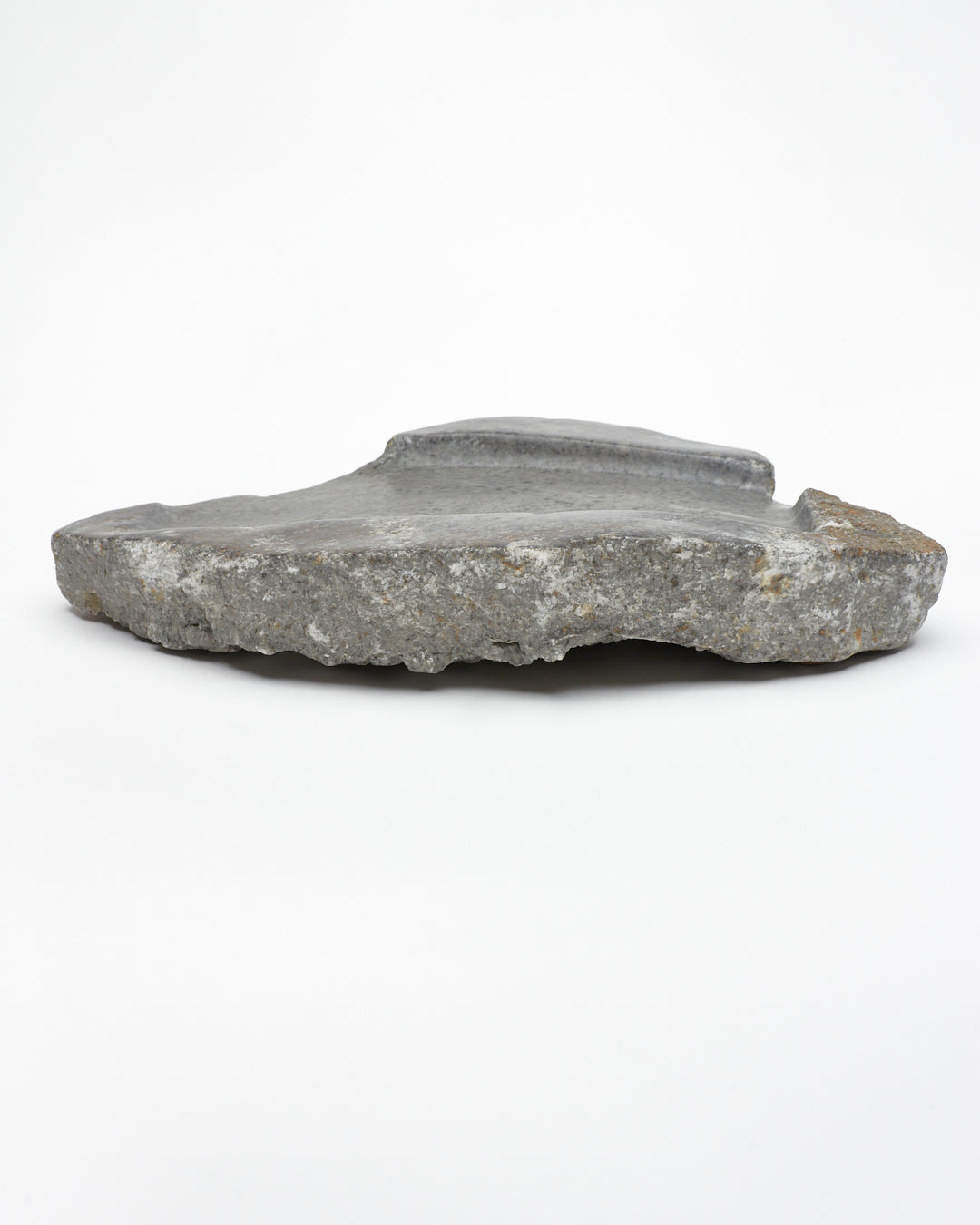 Side: organic-shaped gray stone tray with raw edges, brown and white flecks, subtle veining.