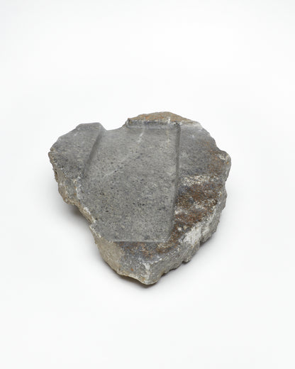 Front: organic-shaped gray stone tray with raw edges, brown and white flecks, subtle veining.