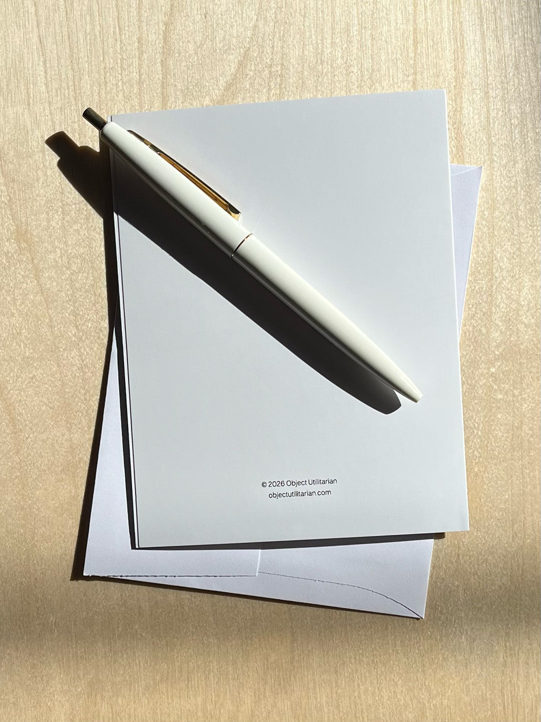 Back of greeting card, text “© 2026 Object Utilitarian objectutilitarian.com” with envelope and pen.