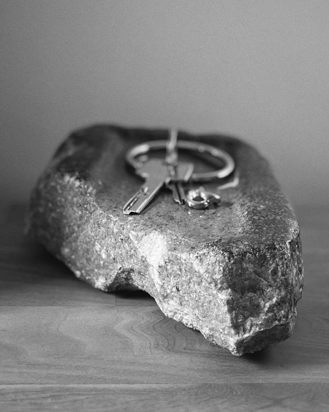 Front-on view: gray stone tray, organic shape, raw edges holding keys and jewelry.